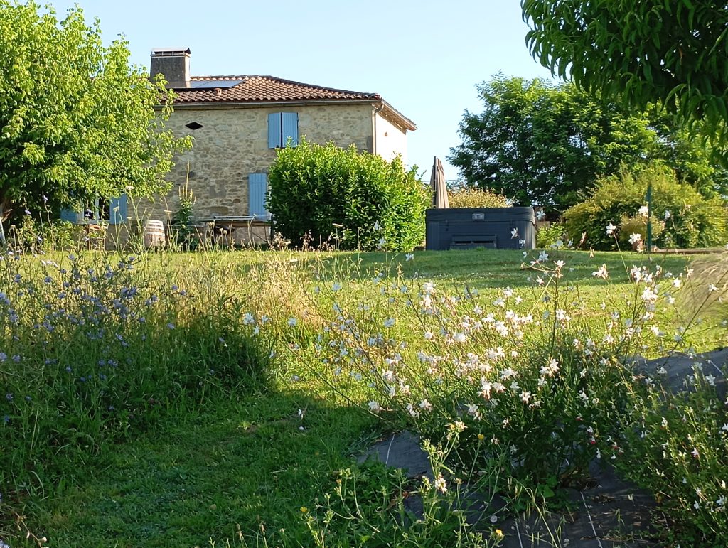 Façade en pierre du gîte à Baleyssagues, typique du Lot-et-Garonne, avec terrasse et vue sur la nature