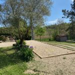 Terrain de pétanque ombragé à côté de la piscine du gîte